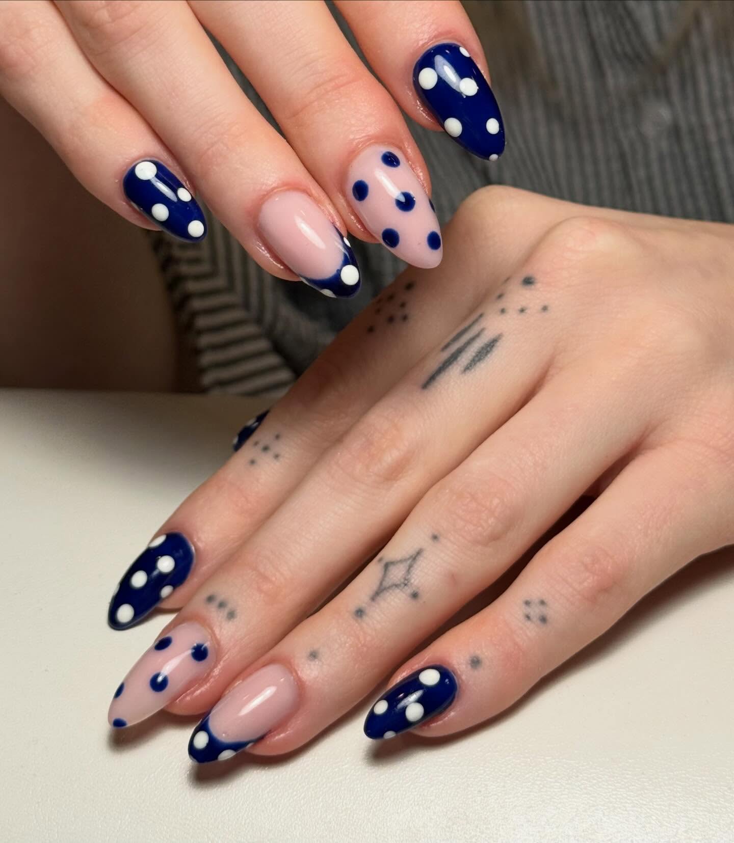 Navy en nude amandelnagels met witte en blauwe stippen