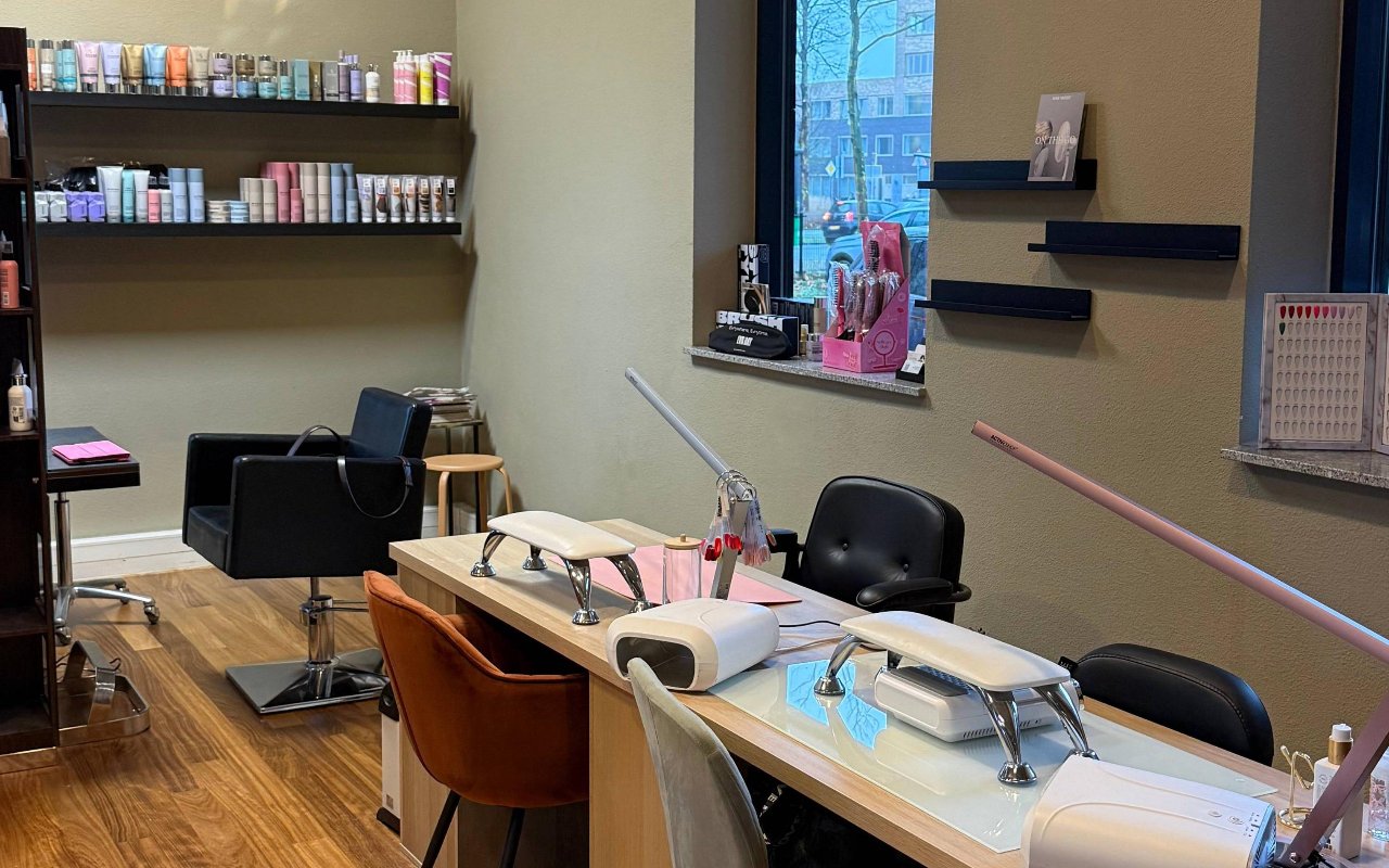 De nageltafel met lampen en de productwand bij het raam